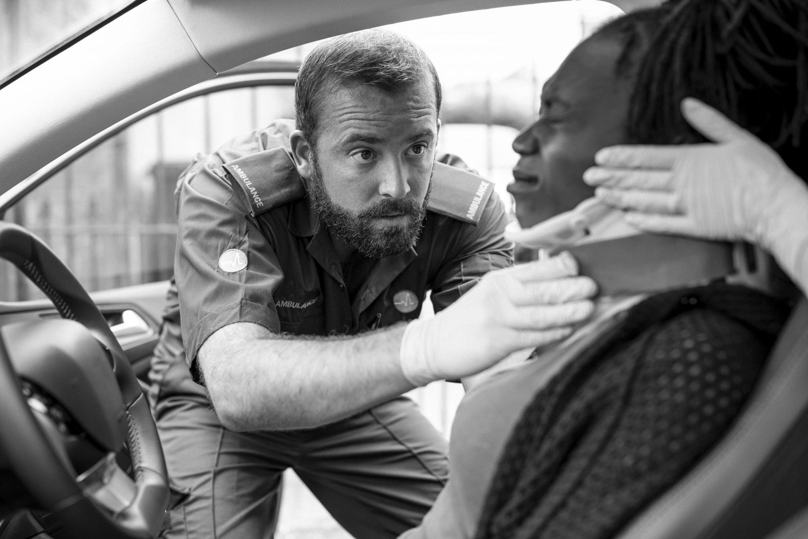 Paramedic placing a cervical collar to an injured woman from car