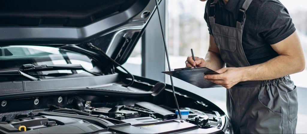 Car mechanic at car service checking up the car