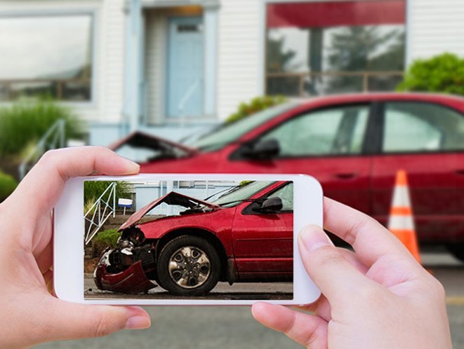 woman taking a picture of a car accident