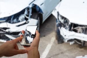 man photographing his vehicle with damages for accident insurance with smart phone